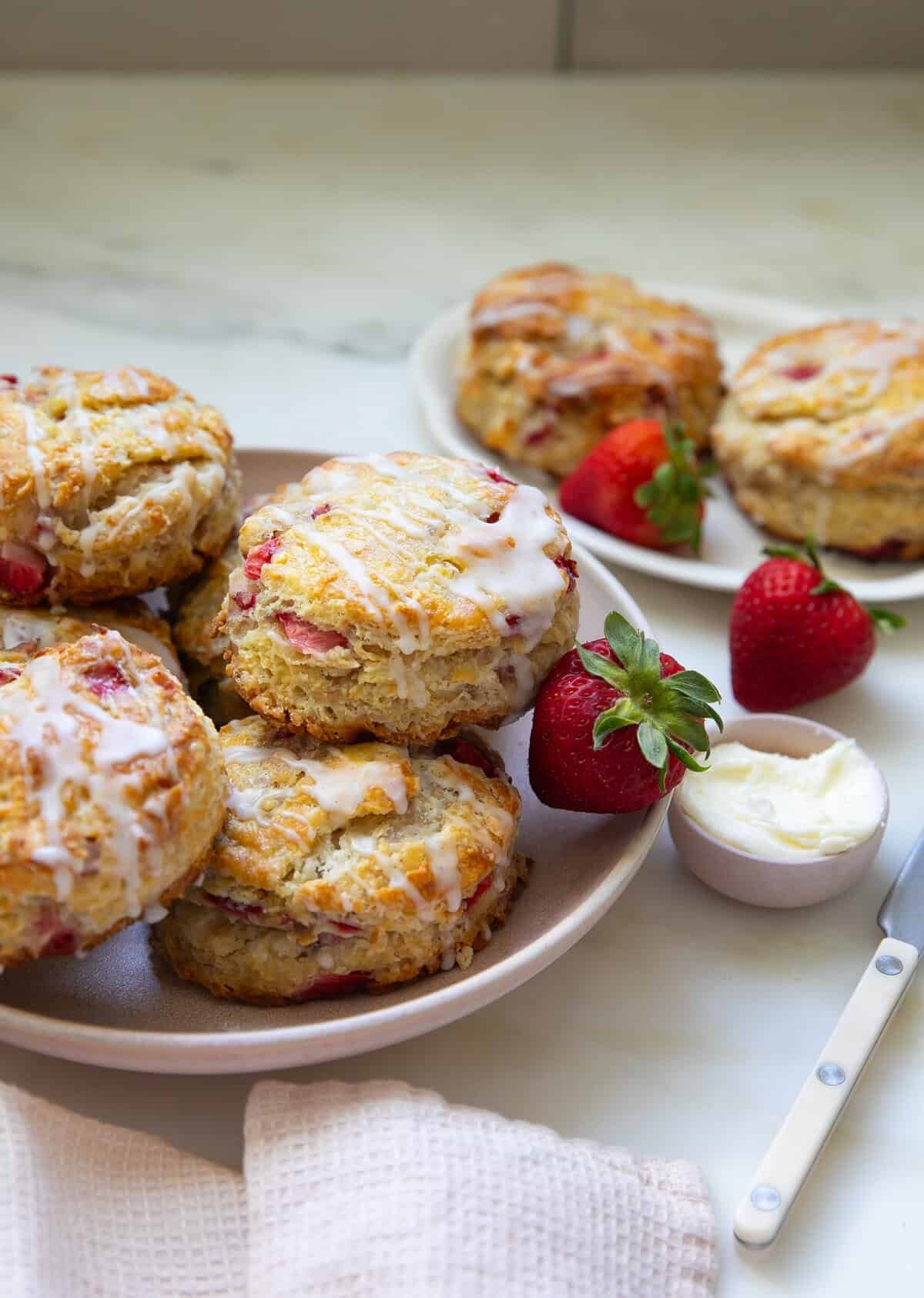 Strawberry Biscuits with strawberries on the side with butter on a plate.