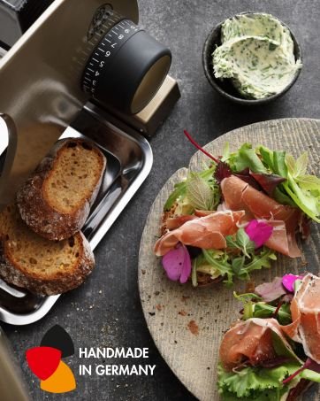 Table setting with salad, toasted bread, and spread. 'HANDMADE IN GERMANY' text and German flag colors visible in corner.